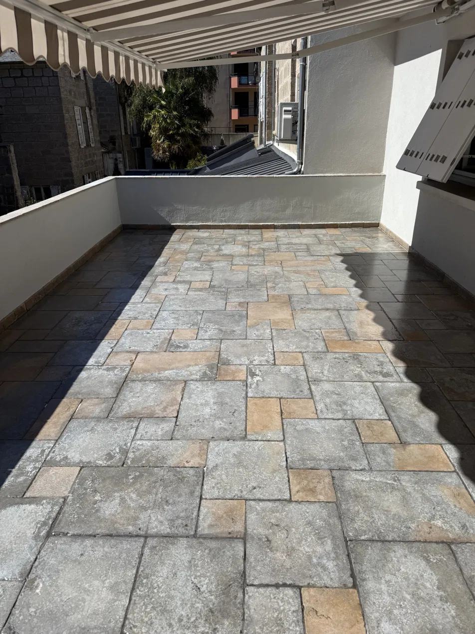 Terrasse sous store après nettoyage, dalles claires