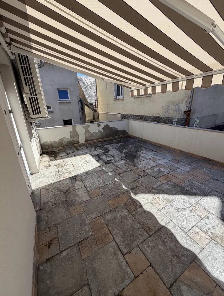Terrasse sous store avant nettoyage, dalles sombres et tachées